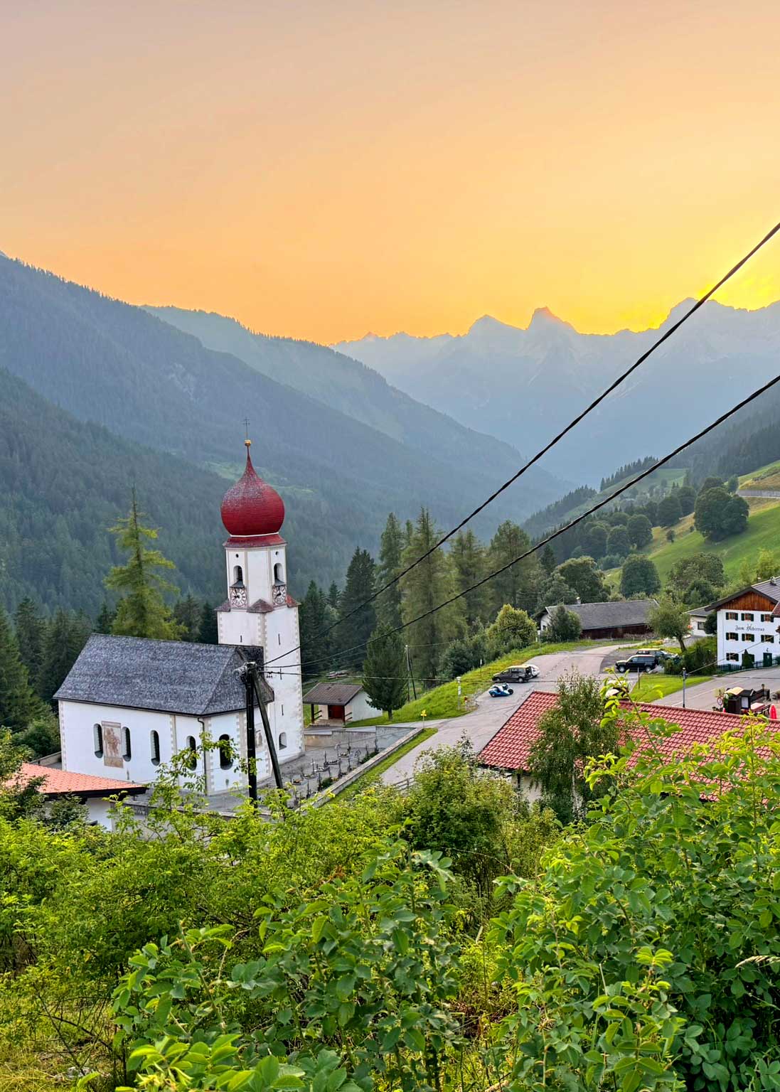Dorfkirche in Berglandschaft in Bschlabs, Tirol bei Sonnenuntergang